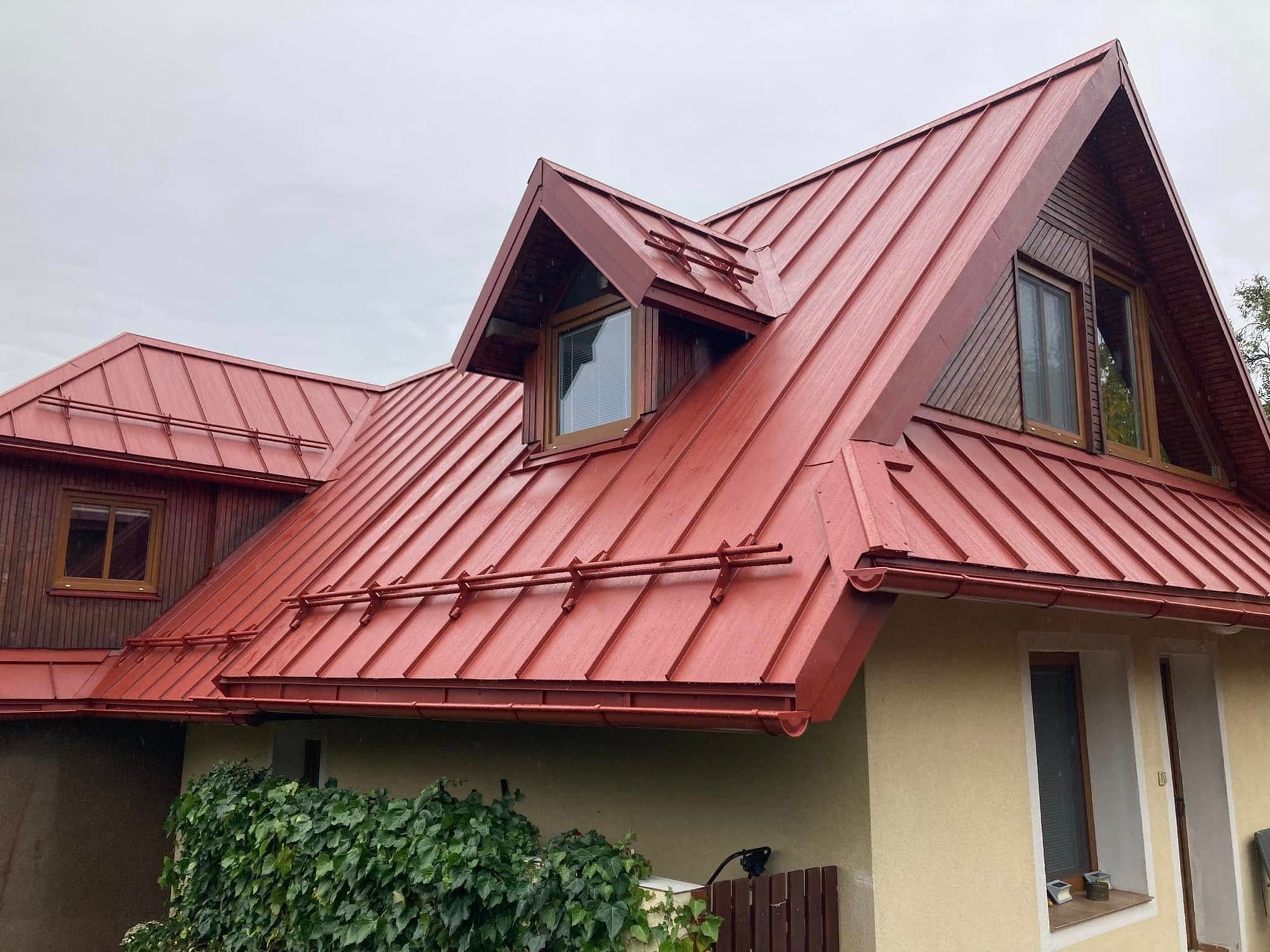 Dokončená strecha rodinného domu s červenou falcovanou krytinou